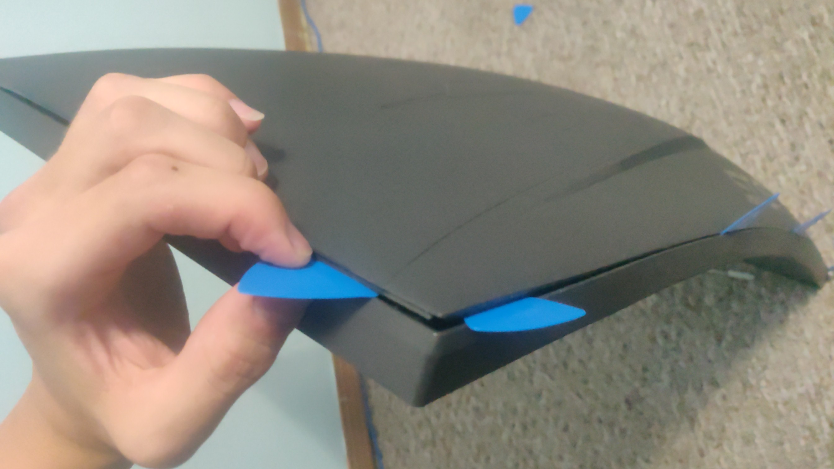 Monitor with plastic spudgers in it with the back corner starting to pop off